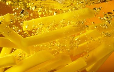 Freeze,Motion,Of,French,Fries,Floating,In,Cooking,Oil.,Junk